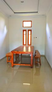 a wooden table in a room with a chair at Wisma KLG 1 in Kaliurang