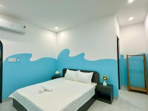 a bedroom with a large bed with a blue wall at SANTORINI 17A - Gần Biển Bãi Sau Đi Bộ Ra Biển in Vung Tau +62 photos