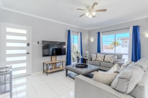 a living room with a couch and a tv at 5 minutes to Eagle Beach Blue Lagoon by Bocobay in Palm-Eagle Beach