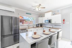 a kitchen with white cabinets and a stainless steel refrigerator at 5 minutes to Eagle Beach Blue Lagoon by Bocobay in Palm-Eagle Beach