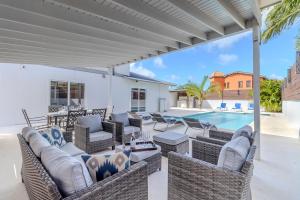 a patio with wicker furniture and a swimming pool at 5 minutes to Eagle Beach Blue Lagoon by Bocobay in Palm-Eagle Beach