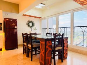a kitchen with a table and chairs and windows at Lake View Castle in Trivandrum