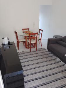 a living room with a couch and a table and chairs at Ap no centro do Vila Branca in Jacareí