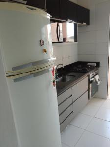 a white kitchen with a refrigerator and a sink at Ap no centro do Vila Branca in Jacareí