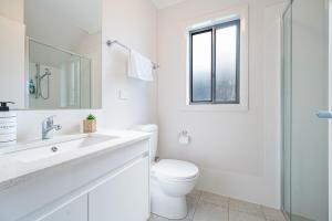 un bagno bianco con un water e un lavandino di Leppington 5Br house near train and shopping a Leppington Altre 14 foto