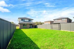 un cortile con recinzione e una casa di Leppington 5Br house near train and shopping a Leppington