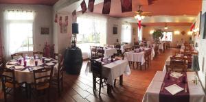 a restaurant with tables and chairs with white tablecloths at Auberge Les Glycines in Cancon