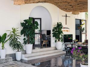 a church lobby with potted plants and a cross on the wall at Hometel Hồng Xuka in Mộc Châu