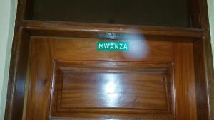 a wooden door with a green sign on it at Mauya Executive Lodge in Dar es Salaam