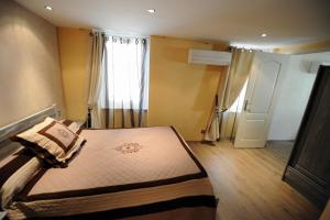 a small bedroom with a bed and a window at Les Arcades in Limoux