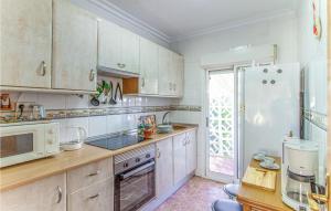 a kitchen with white cabinets and a white refrigerator at Awesome Apartment In Santa Pola in Santa Pola