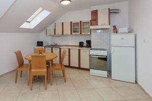 a kitchen with a table and a white refrigerator at Apartment Lermontov in Burgas