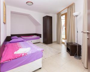 a bedroom with a purple and white bed and a window at Apartment Lermontov in Burgas City