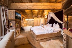 ein Schlafzimmer mit einem Bett und einer Badewanne in einem Zimmer in der Unterkunft Romantiksuite in Alpbach