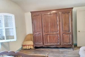 a large wooden cabinet in the corner of a room at Maison spacieuse avec jardin à Lathus-Saint-Rémy, 160 m², barbecue in Ouzilly