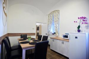eine Küche mit einem Tisch, Stühlen und einer Mikrowelle in der Unterkunft Főtér Apartman in Eger