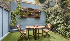 a wooden table and two chairs on a patio at Casa palmar sercas del Nilo in Mexico City