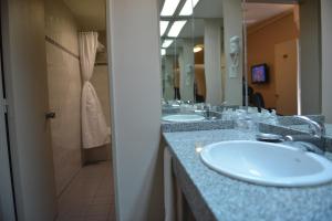 a bathroom with two sinks and a shower at Comodoro Hotel in Comodoro Rivadavia +25 photos