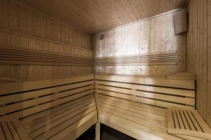 a sauna with wooden walls and benches in it at Apartamenty Sun & Snow Polanki z sauną in Kołobrzeg