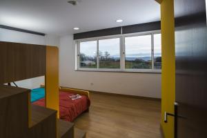 1 dormitorio con cama y ventana grande en Hostel EntryFik, en Maçeira