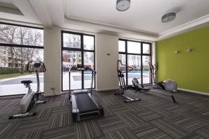 a gym with treadmills and exercise equipment in a room with windows at Apartamenty Sun & Snow Polanki z sauną in Kołobrzeg