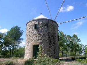 an old stone windmill in a field at Hostel EntryFik in Maçeira