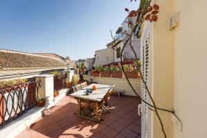 un patio con tavolo in legno sul balcone. di Trevi Charming Penthouse a Roma