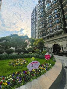 Bund Branch New west door 2 bedrooms big house في شانغهاي: حديقة من الزهور في حديقة في مدينة