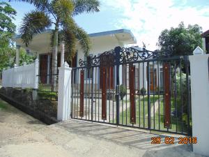 ein Tor vor einem Haus mit einer Palme in der Unterkunft Sun Hill Home in Weligama