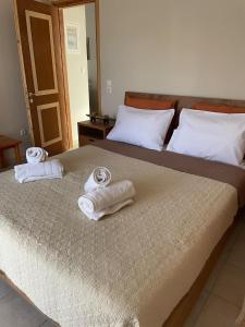 una camera da letto con due letti con asciugamani sopra di Rodopi Apartment a Skala di Cefalonia Altre 18 foto