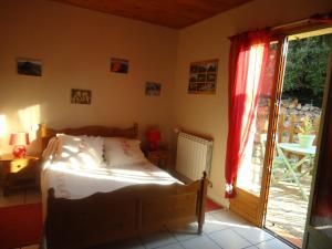 a bedroom with a bed and a sliding glass door at La Claouzo in Duilhac