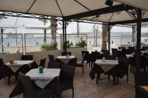 ブリンディジにあるB&B Le Colonneのビーチを望むテーブルと椅子付きのレストラン