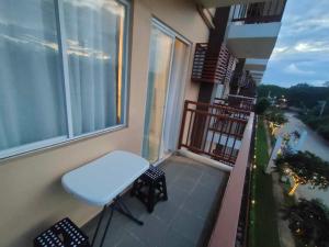 a balcony with a white stool and a window at Cozy and Affordable Deluxe Condo near Puerto Princessa Airport in Puerto Princesa City