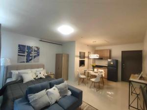 a bedroom with a bed and a kitchen with a table at Cozy and Affordable Deluxe Condo near Puerto Princessa Airport in Puerto Princesa City