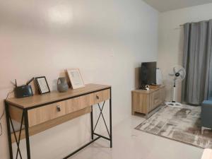a room with a table with pictures and a fan at Cozy and Affordable Deluxe Condo near Puerto Princessa Airport in Puerto Princesa City