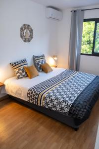 a bedroom with a large bed with pillows on it at La Ŵilla, piscine et parking privatisées, accès mer, sentiers et volcans!! in Saint-Joseph