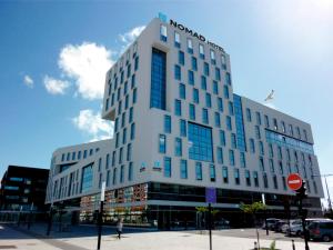 a tall white building with a sign on it at Nomad Hotel le Havre Centre Gare in Le Havre