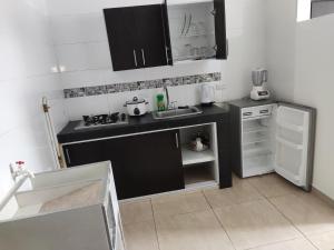 a kitchen with a black counter top and a sink at Edificio Wil Hostal Apt 201 in Cali +5 photos