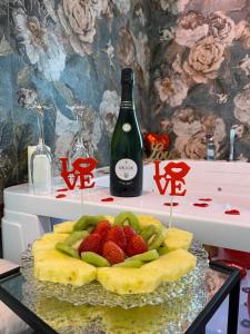 a table with a bottle of wine and a plate of fruit at Al Baglio Apartments in Partinico