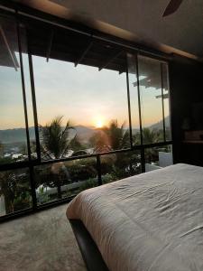 1 dormitorio con cama y vistas a la puesta de sol en Sky Lofts Phuket 2, en Thalang