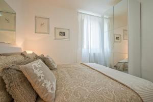 ein weißes Schlafzimmer mit einem Bett und einem Fenster in der Unterkunft Vatican Holiday Apartment 317 in Rom