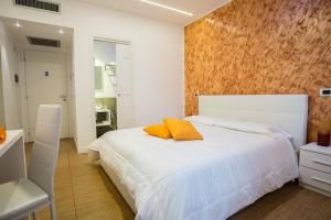 een slaapkamer met een wit bed met 2 oranje kussens erop bij Valle Aurelia House in Rome