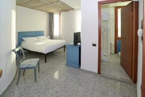 a bedroom with a bed and a chair and a television at L'incanto Di Boccadarno in Marina di Pisa