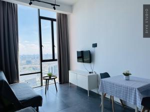 a white room with a table and a tv and some windows at Five Studio - Empire Damansara in Petaling Jaya