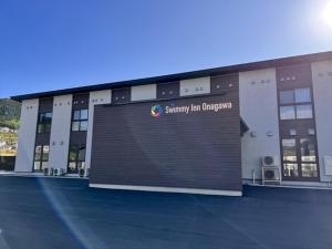 ein großes Gebäude mit einem Schild an der Vorderseite in der Unterkunft Ｓｗｉｍｍｙ Ｉｎｎ Ｏｎａｇａｗａ - Vacation STAY 44047v in Onagawa