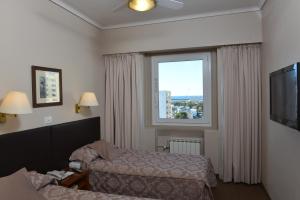 a hotel room with a bed and a window at Comodoro Hotel in Comodoro Rivadavia