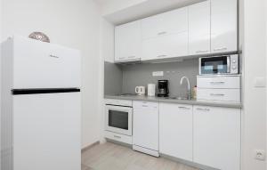 a white kitchen with white cabinets and appliances at 2 Bedroom Gorgeous Apartment In Podaca in Podaca