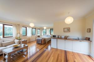 Una cocina y una sala de estar con un sofá y una mesa. en Avalon River Retreat - 400 acre off the grid riverside nature & platypus oasis, en Ellenborough