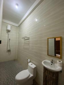 a bathroom with a toilet and a sink at Npdc Comfy Hotel in Toyapakeh