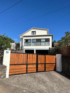 a house with a wooden gate and a fence at Maison de vacances du sud in Saint-Joseph